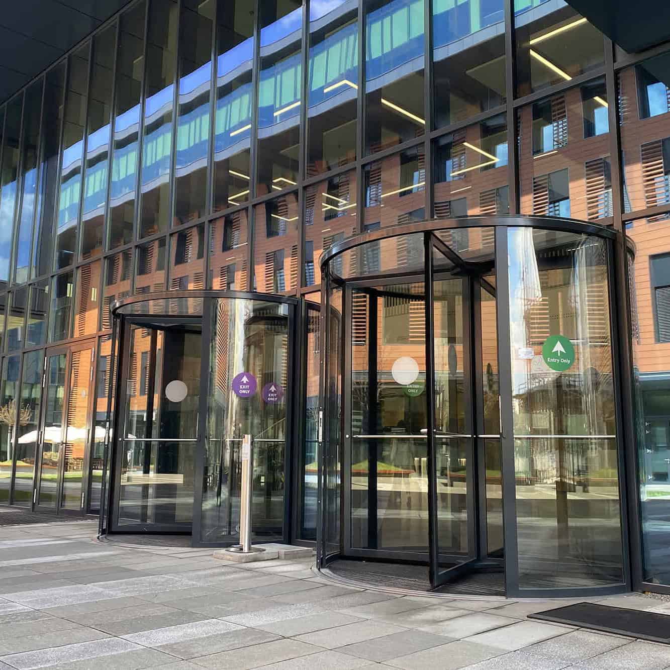 Automatic glass revolving doors for modern buildings.