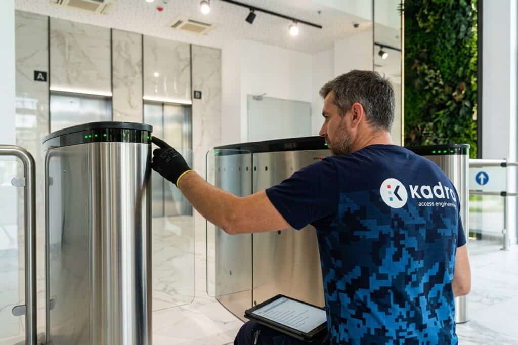 Technician checking the Kadra access control system at the building entrance.