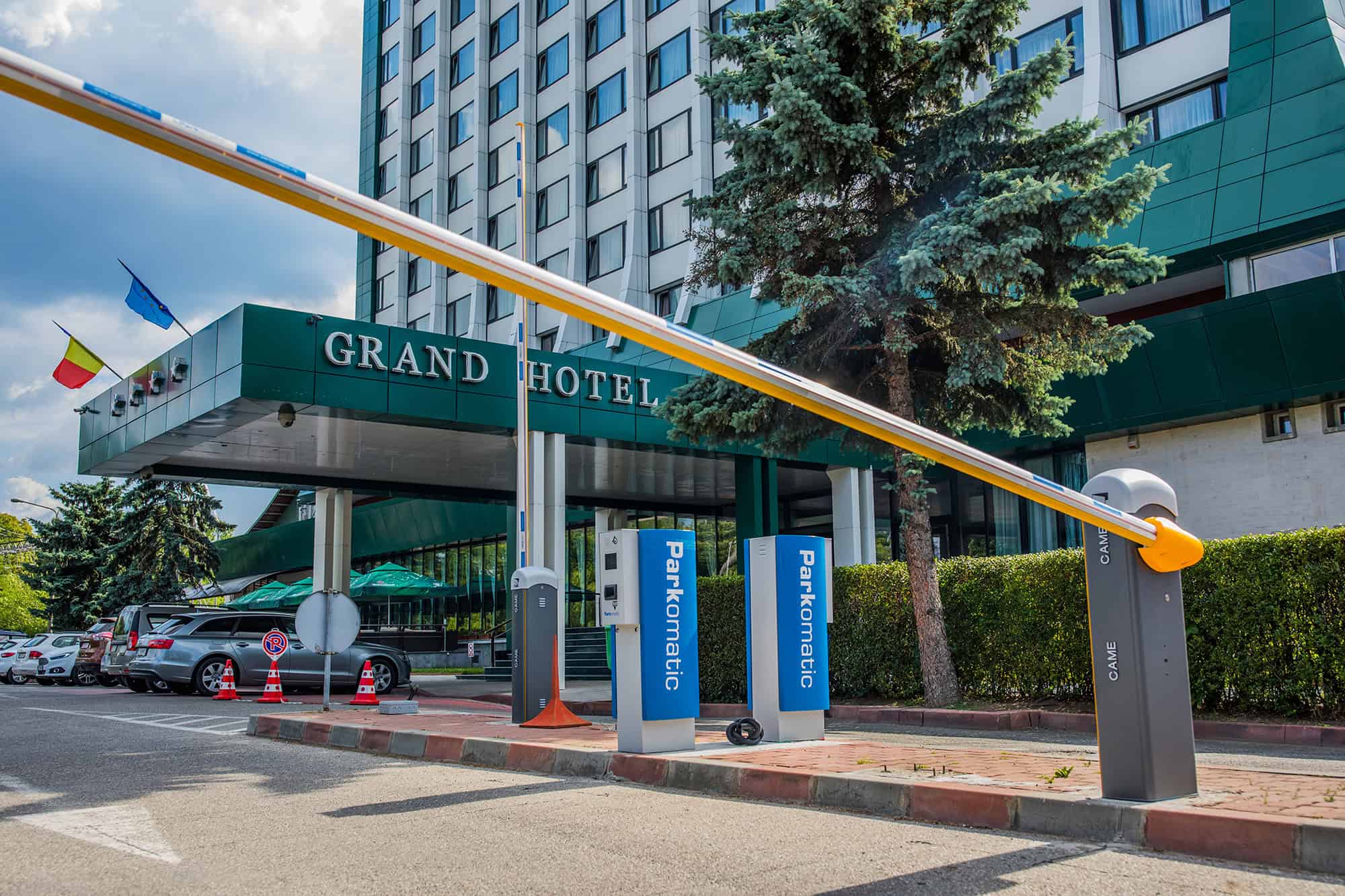 Sistem automat de parcare pentru hotel, cu barieră și stații de plată.