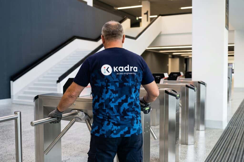 Person using Kadra access control turnstiles inside a modern space.