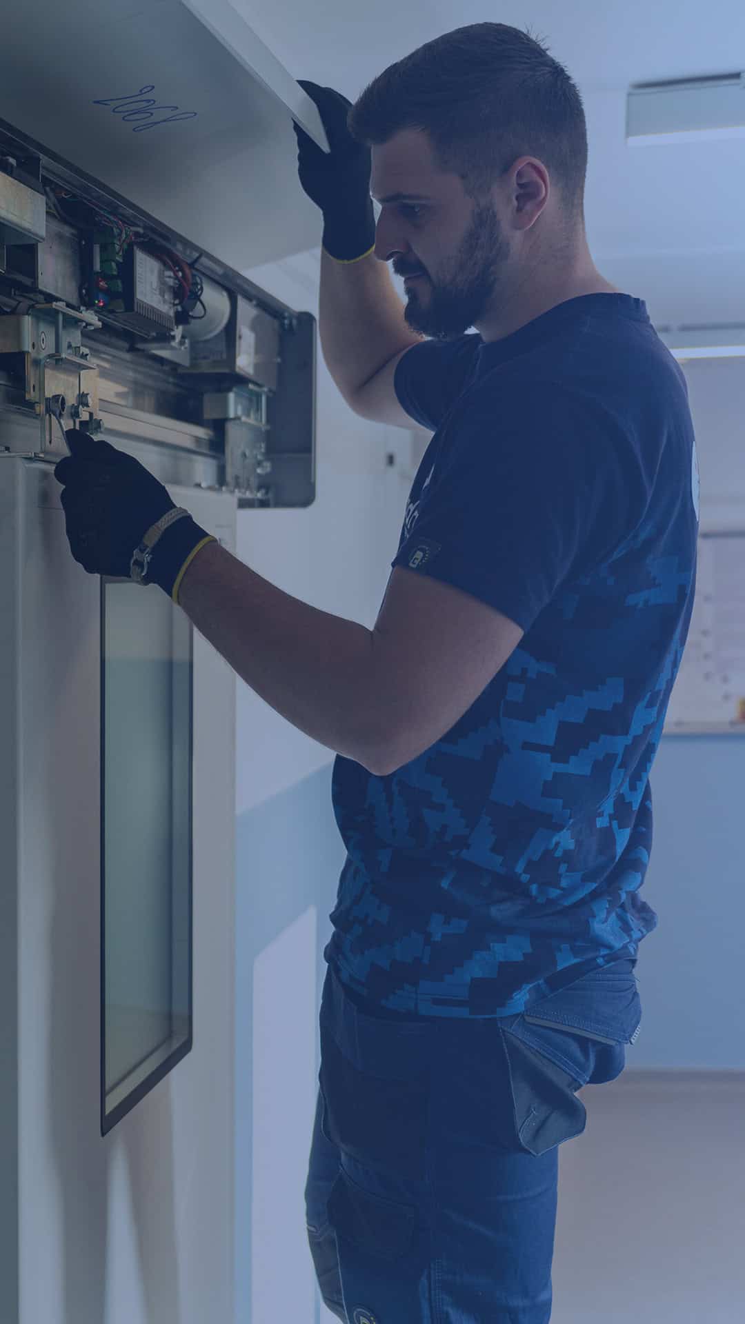 Technician repairing or checking an electrical panel for automatic doors.