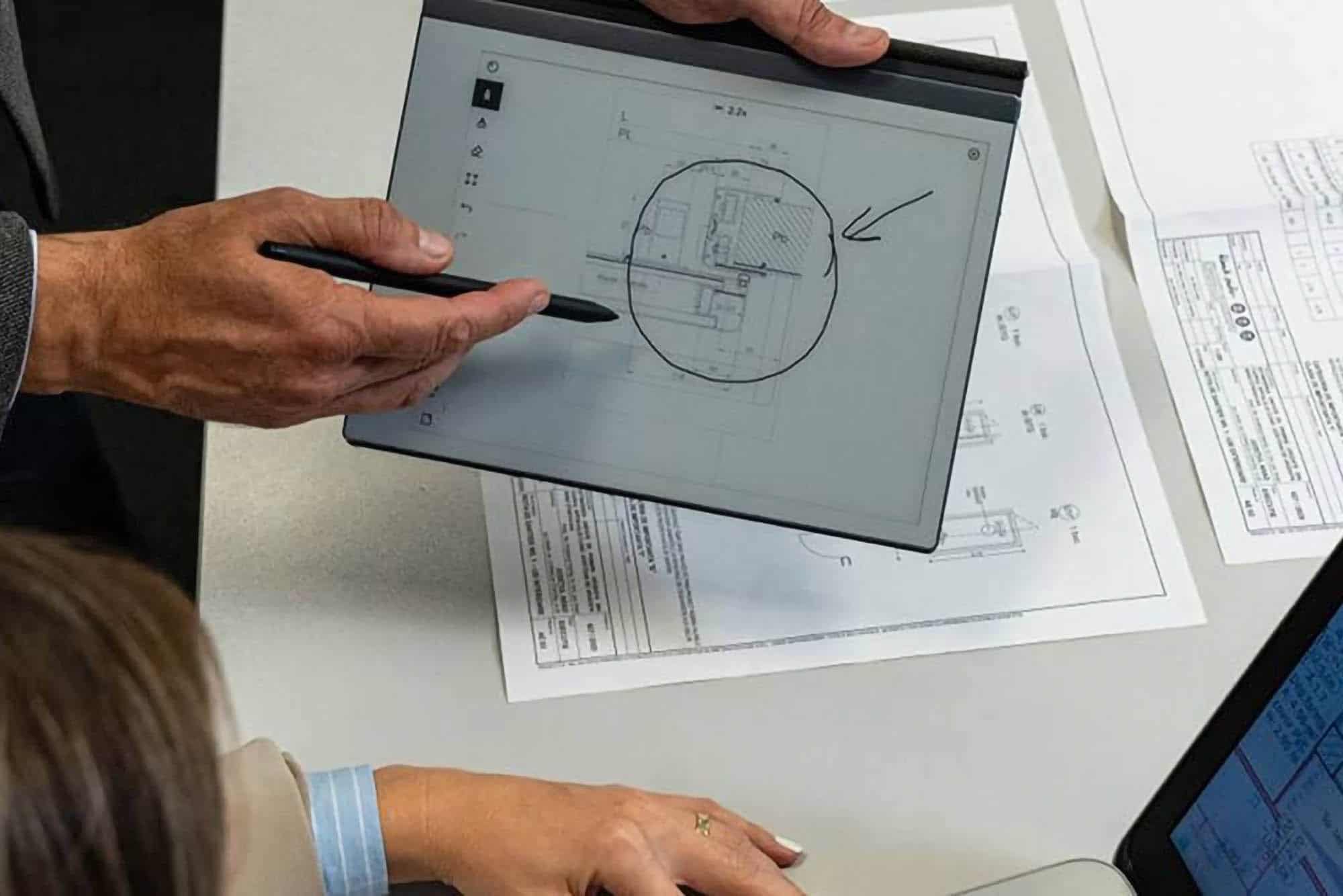 Technician analyzing technical plans on a tablet for maintenance.